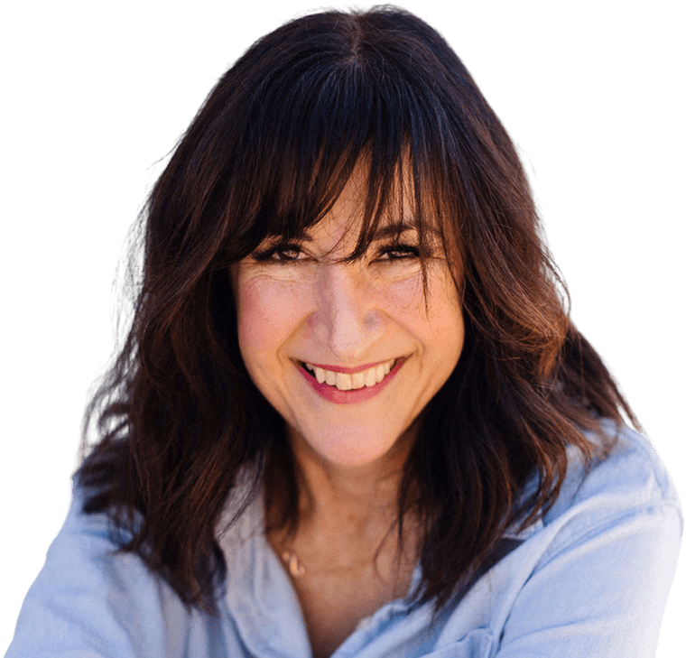 Christy Stewart, seated and leaning forward, smiling, in a light blue shirt